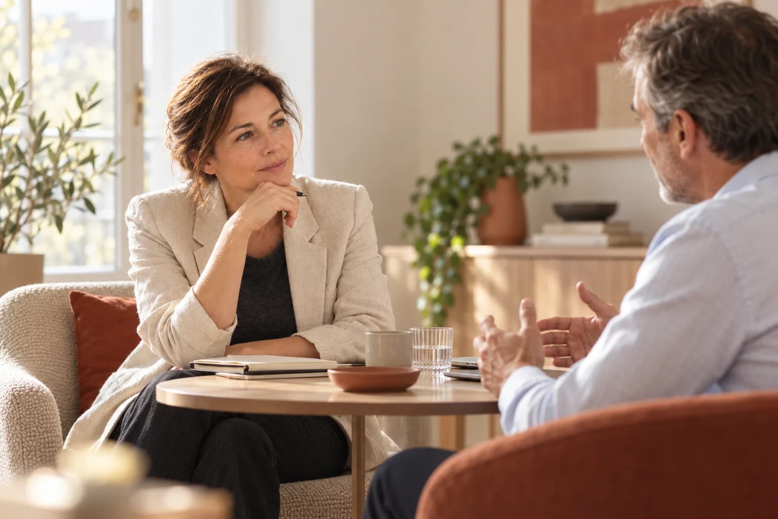Consultante à l’écoute d’un dirigeant lors d’un entretien en tête-à-tête autour d’une table basse